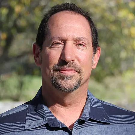 Man with goatee wearing striped shirt.