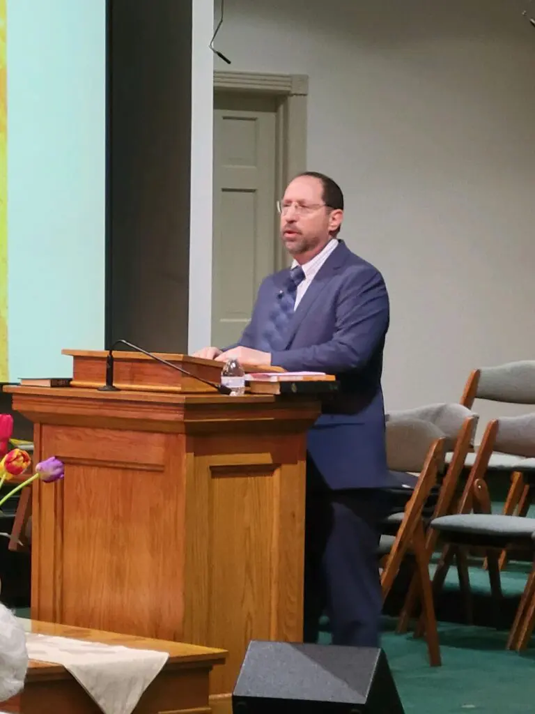 Man in suit speaking at a podium.